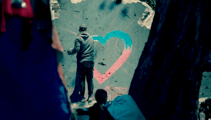 Man in Gaza sprays a colourful heart symbol on a dishevelled wall